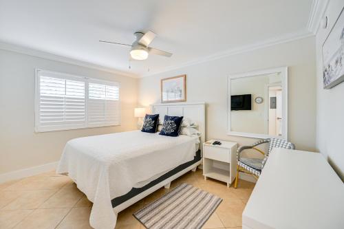 a white bedroom with a bed and a window at Naples Condo with Pool - Walk to Dining and Beach in Naples