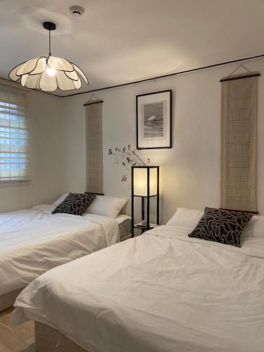 a bedroom with two beds and a chandelier at YongDamJae in Seoul