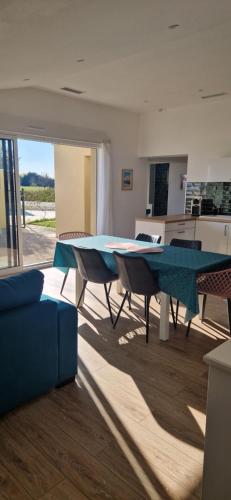 un salon avec une table bleue et des chaises dans l'établissement La jolie Pradelle, à Virsac