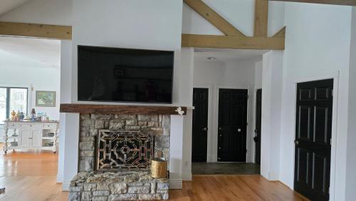 a living room with a stone fireplace with a flat screen tv at Beautiful Kentucky Derby Rental Home Accommodating 10 Guests or More in Louisville