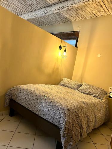 une chambre avec un lit et une lumière sur le mur dans l'établissement Grand Loft et Terrasse Privée - Coeur Historique d'Aix !, à Aix-en-Provence