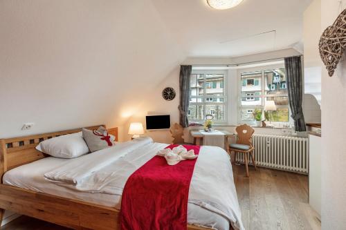 a bedroom with a large bed with a red blanket at Villa Sunside Appartements in Schluchsee