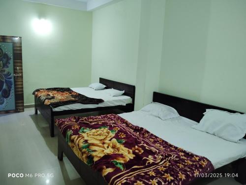 two beds in a hotel room withskirts at Hotel Shri Ram Palace in Rewa