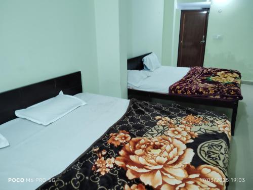 two beds in a hotel room with a blanket at Hotel Shri Ram Palace in Rewa