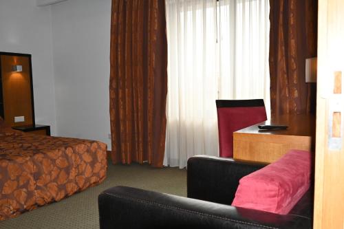 a hotel room with a bed and a couch at Hotel Bagoeira in Barcelos