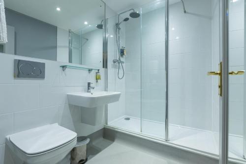 a bathroom with a shower and a toilet and a sink at Blue Boar Hotel in Maldon
