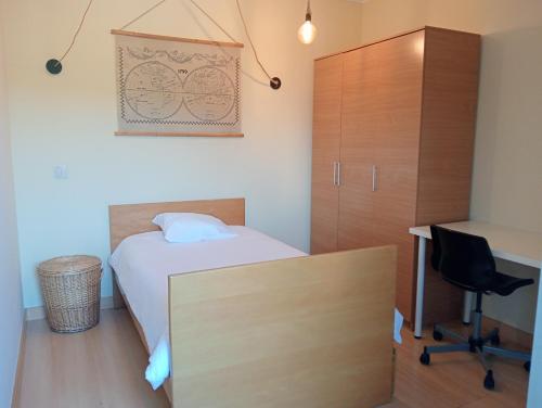 a bedroom with a bed and a desk and a cabinet at Oporto Spacious AP 4 bedroom in Pedrouços