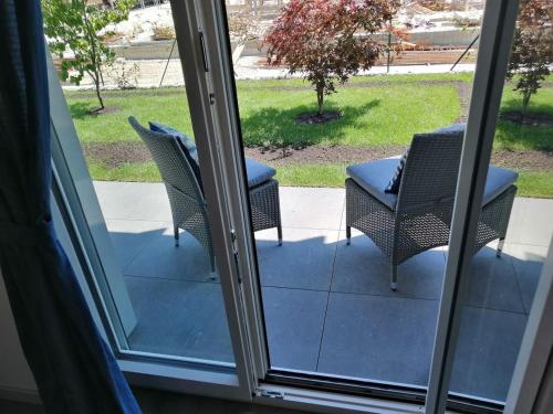 an open door with two chairs on a patio at Nuovo appartamento 5 minuti a piedi dal Policlinico in San Donato Milanese