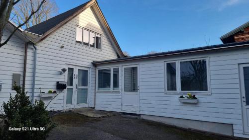 a white house with two windows on the side of it at A charming apartment in the heart of Roskilde in Roskilde