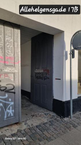 a black door with graffiti on the side of a building at A charming apartment in the heart of Roskilde in Roskilde