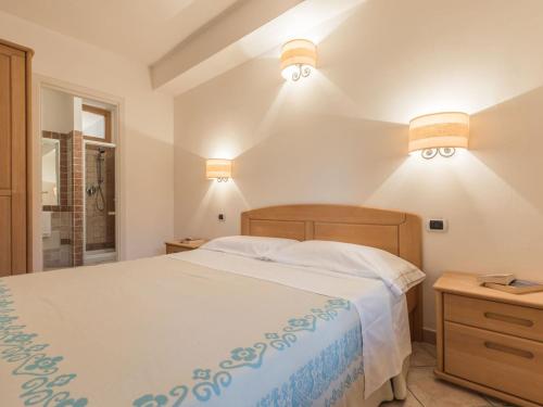 a bedroom with a bed and two lights on the wall at Capo Ceraso Family Resort in Costa Corallina