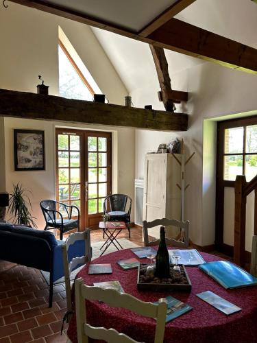 un salon avec une table et des chaises dans l'établissement Petite maison et grand jardin Wifi Mer a 20 minutes, à Royville