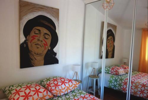 Una habitación con dos camas y un cuadro en la pared. en Maisonette Plage, en La Ciotat