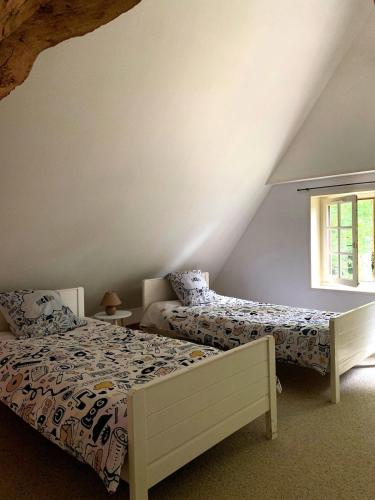 une chambre avec deux lits et une fenêtre dans l'établissement Petite maison et grand jardin Wifi Mer a 20 minutes, à Royville