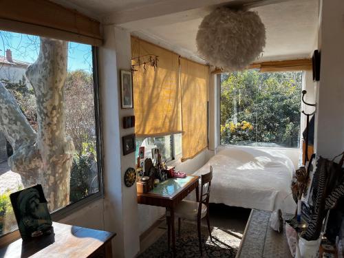 Un dormitorio con una cama y un escritorio y una ventana. en Jardin d'eden, en La Ciotat