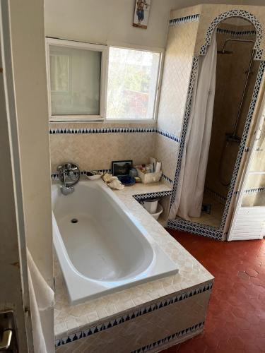 une salle de bain avec une grande baignoire et un miroir dans l'établissement Jardin d'eden, à La Ciotat