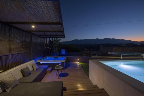 a rooftop patio with a hot tub and a pool at Almi-Cove Hilltop Villas in Almirida