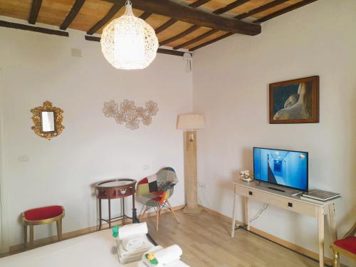 a living room with a tv and a table and chairs at Appartamento Palma in Spello