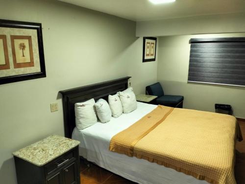 a hotel room with a bed and a chair at hotel economico in Tijuana