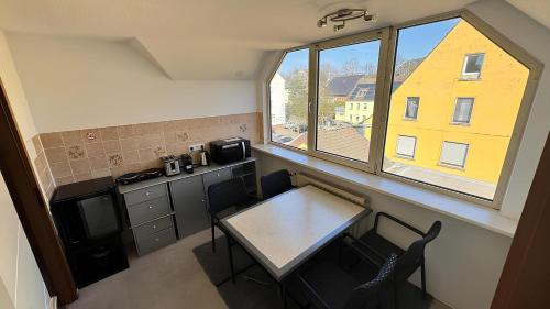 a small kitchen with a table and a window at Hotel Specht by Trotmannia in Dortmund