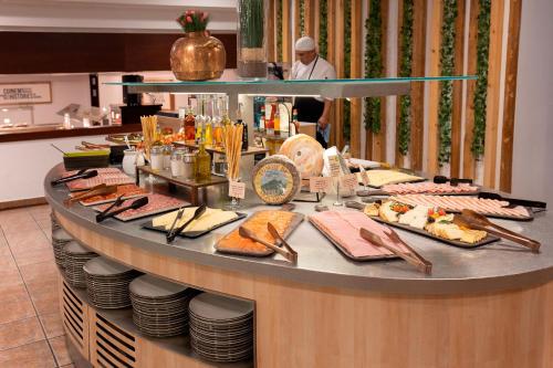 a buffet with food on a counter in a restaurant at Hotel Piolets Soldeu Centre by Nexta in Soldeu