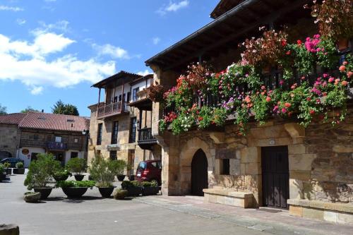 a building with flowers on the side of it at La Casita del Montañes in Liérganes