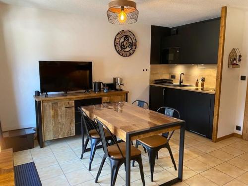 une salle à manger avec une table et une cuisine dans l'établissement Le Cocon des Cîmes, aux Contamines-Montjoie