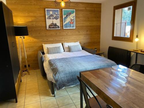 une chambre avec un lit et une table dedans dans l'établissement Le Cocon des Cîmes, aux Contamines-Montjoie