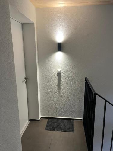 a hallway with a wall with a light on it at Neue helle Wohnung mit Bergblick am Eingang der Jungfrau Region und Berner Oberland in Aeschi bei Spiez