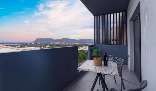 a balcony with a table with a bottle of wine at Seascape Luxury Apartment 2 in Kounoupidhianá
