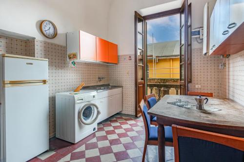 a kitchen with a washing machine and a table at Il Nido - accogliente rifugio in centro a Pisa in Pisa