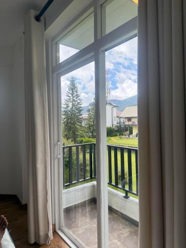 a sliding glass door with a view of a balcony at Nomentano Blue -Luxury Apartments- in Nuwara Eliya