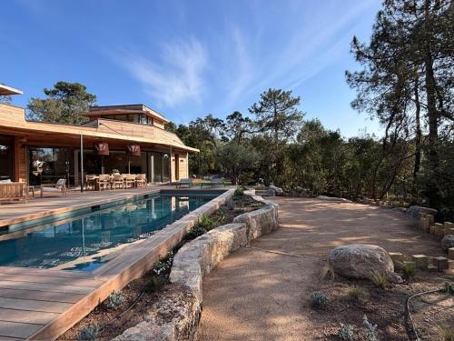 une maison avec une piscine devant une maison dans l'établissement Villa L'Immortelle, à Lecci