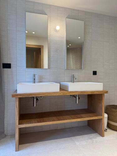 une salle de bain avec deux lavabos et deux miroirs dans l'établissement Villa L'Immortelle, à Lecci