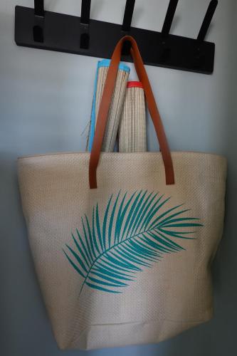 a tan bag with a palm leaf painted on it at Ithaka Beach House, unieke plek met vrij parkeren! in Noordwijk