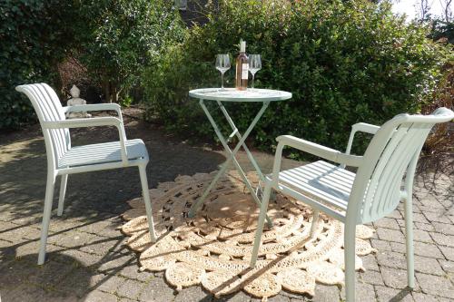 two chairs and a table with a wine glass at Ithaka Beach House, unieke plek met vrij parkeren! in Noordwijk