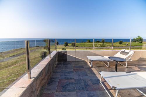 un patio avec une table et des chaises et l'océan dans l'établissement Chalet junto al mar, à Castro Urdiales