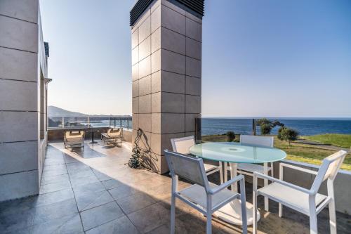 un patio avec une table et des chaises et l'océan dans l'établissement Chalet junto al mar, à Castro Urdiales