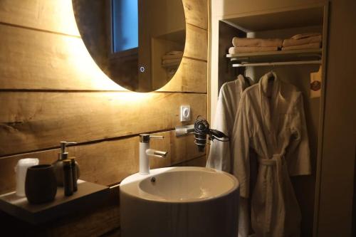 une salle de bain avec un lavabo et un miroir dans l'établissement Suite Charme Loveroom La Manova Spa&Sauna, à Saint-Martin-dʼAuxigny