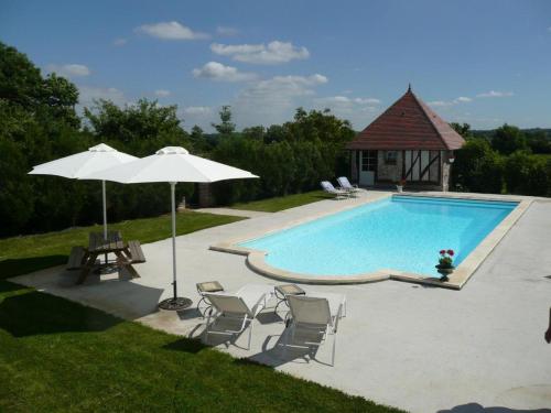 - une piscine avec un parasol, des chaises et une table dans l'établissement La Commanderie et son Cottage PISCINE - SAUNA - 12pers, à Le Sap-André