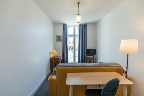 a bedroom with a bed and a desk and a table at Le clos bleu in Labastide-dʼArmagnac