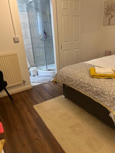 a bedroom with a bed and a bathroom with a shower at House of Nico Corby in Rockingham