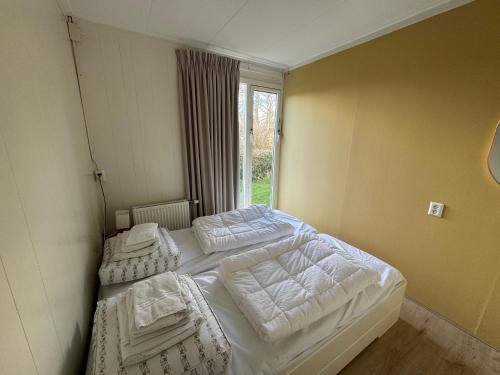 Postel nebo postele na pokoji v ubytování Familie bungalow aan het meer