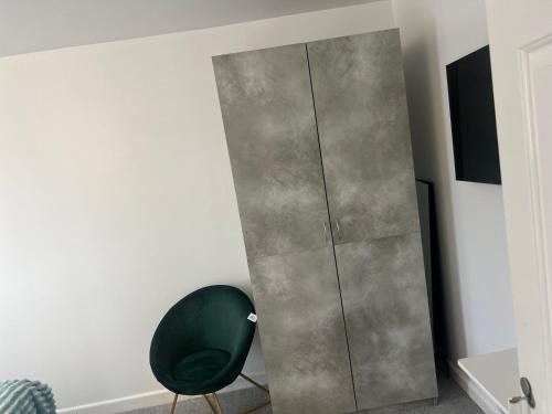 a green chair sitting next to a tall cabinet at House of Nico Corby in Rockingham