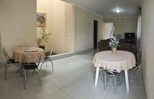 two tables and chairs in a living room at Casa Térrea 3 quartos, sendo 1 suíte Maringá in Maringá