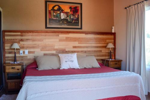 a bedroom with a large bed with a wooden headboard at Casa Almendro-Chumamaya-Villa de Merlo in Country Club Chumamaya
