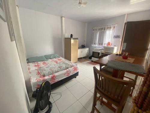 ein Schlafzimmer mit einem Bett, einem Schreibtisch und einem Tisch in der Unterkunft Casa de férias em Gravatá, Navegantes perto da praia in Navegantes