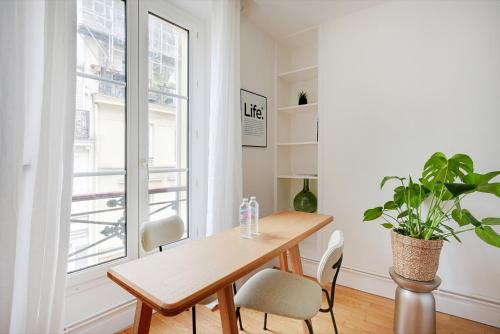une salle à manger avec une table, des chaises et une plante dans l'établissement Charmant 2P à Paris, rue Rodier - Proche de l'Opéra Garnier, à Paris