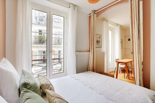 une chambre avec un lit et un grand miroir dans l'établissement Charmant 2P à Paris, rue Rodier - Proche de l'Opéra Garnier, à Paris