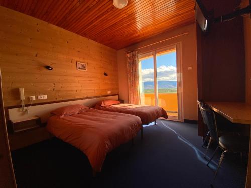 deux lits dans une chambre avec une fenêtre dans l'établissement Relais du Belloch, à Angoustrine